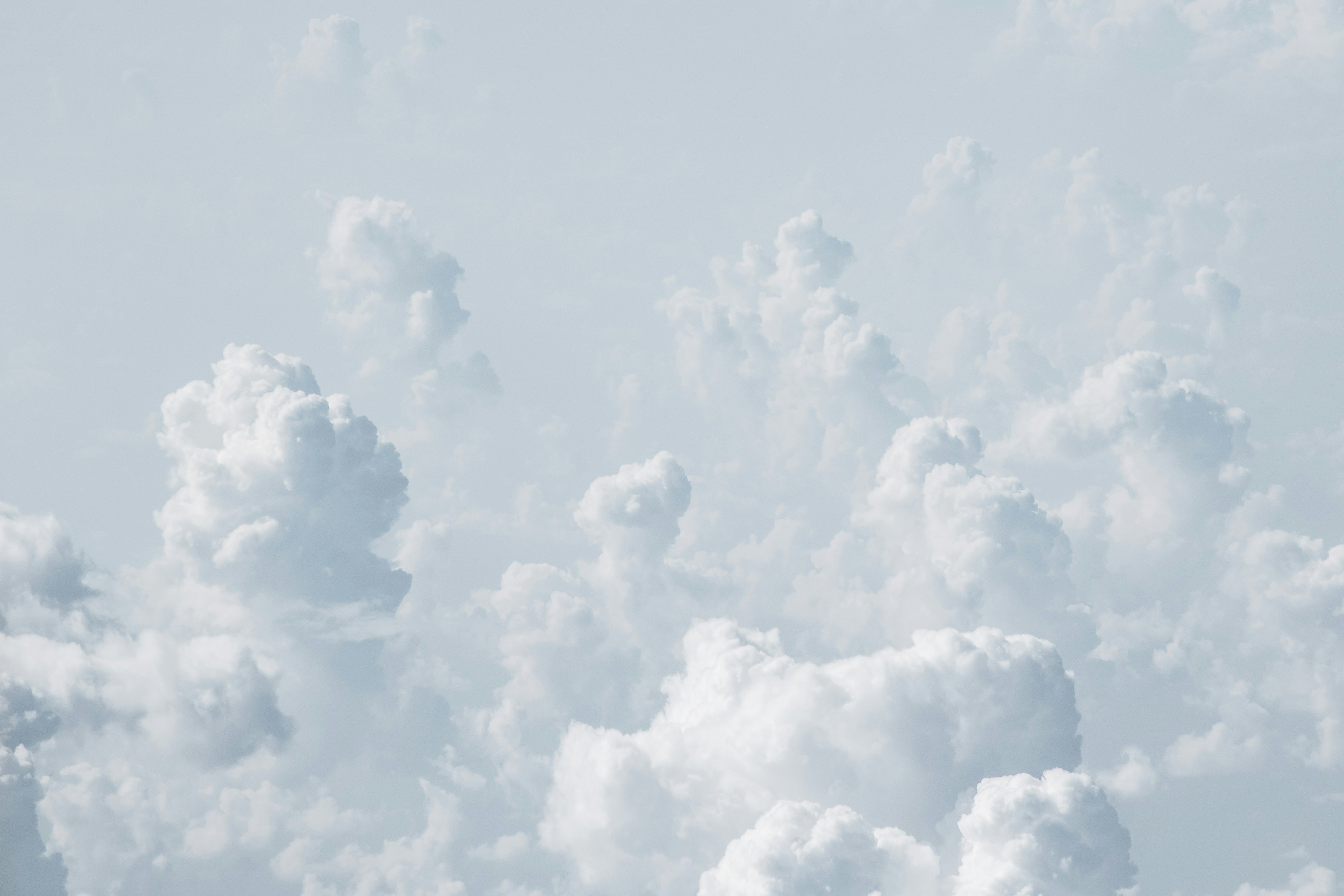 Soft cumulus clouds in pale blue sky
